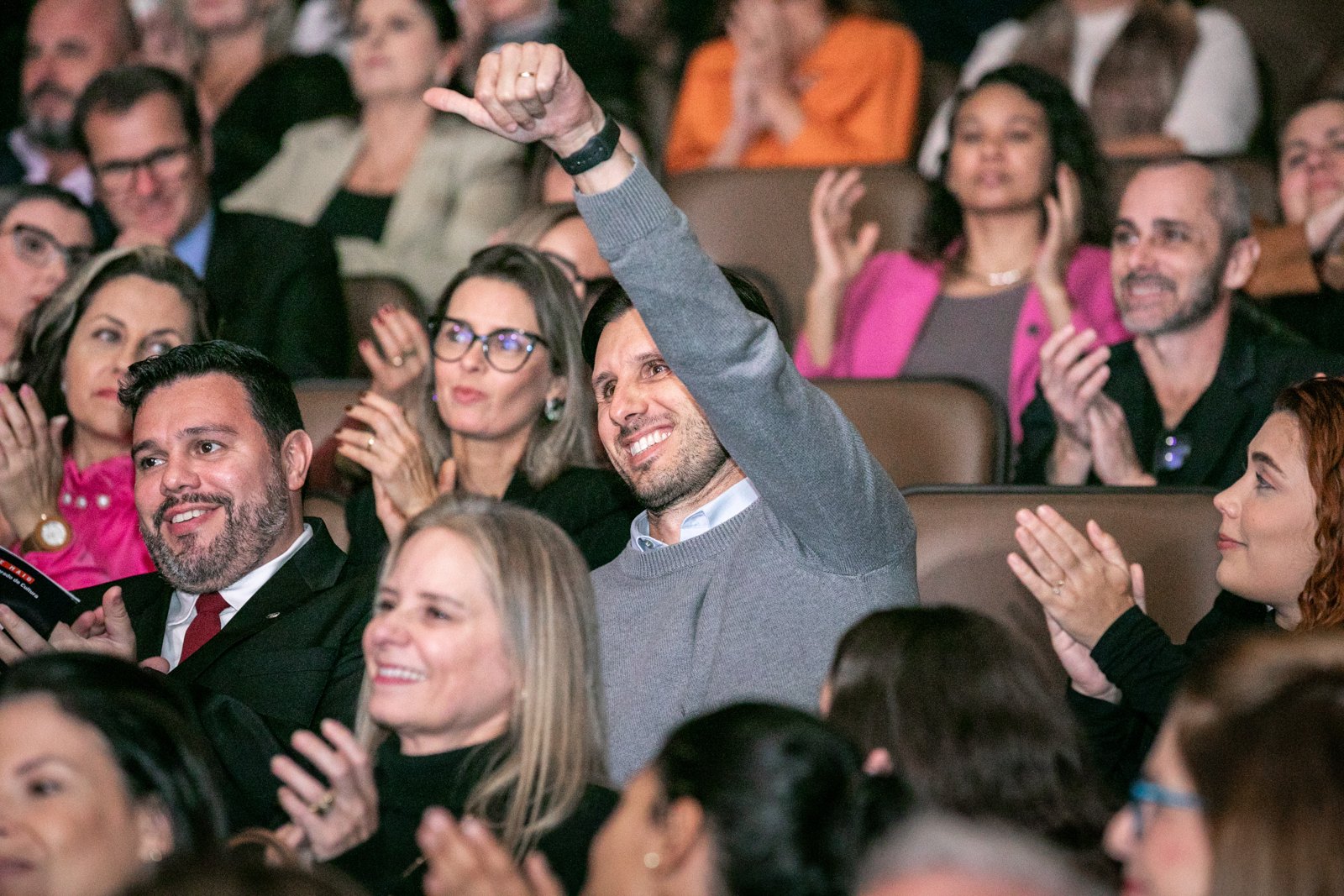 Plateia aplaudindo de pé durante a palestra